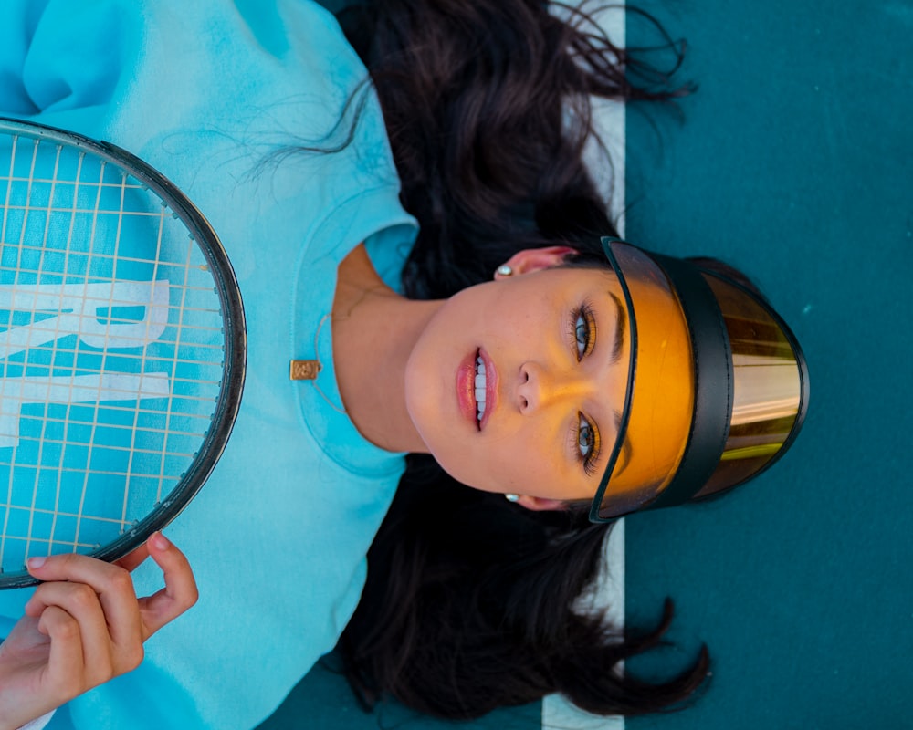 woman in teal crew neck shirt holding yellow and black portable speaker