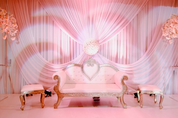 A minimalist lounge setup featuring plush white seating accented with gold pillows