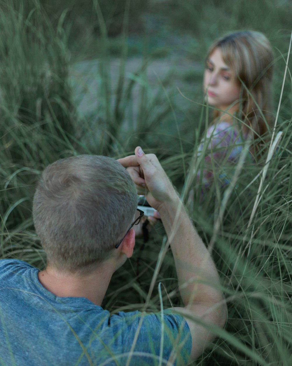 man in blue crew neck t-shirt holding girl in green t-shirt