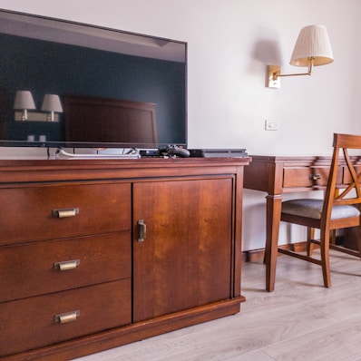 black flat screen tv on brown wooden drawer