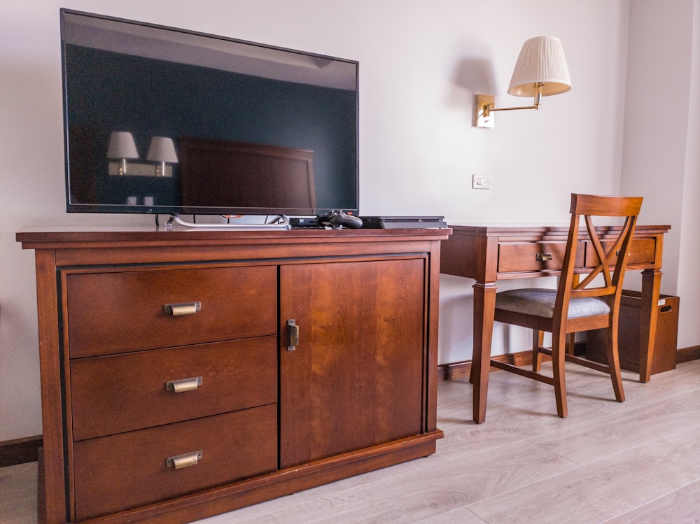 black flat screen tv on brown wooden drawer