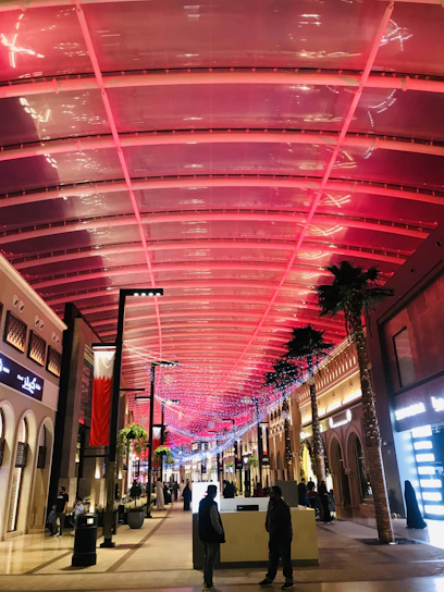 A vibrant shopping center corridor with diverse storefronts and welcoming shoppers.