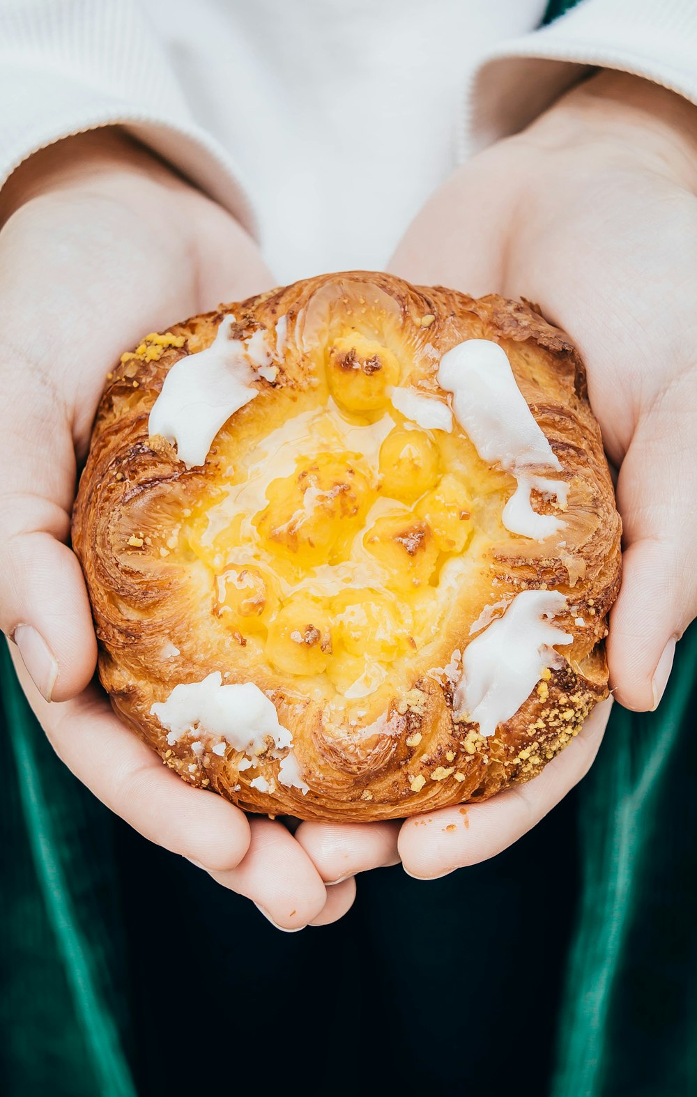 person holding brown bread with yellow cream