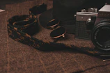 Flat lay of folded golden cotton t-shirts with a vintage camera and sunglasses.
