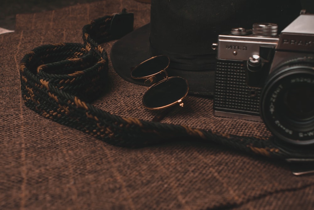 black and silver dslr camera beside black framed eyeglasses