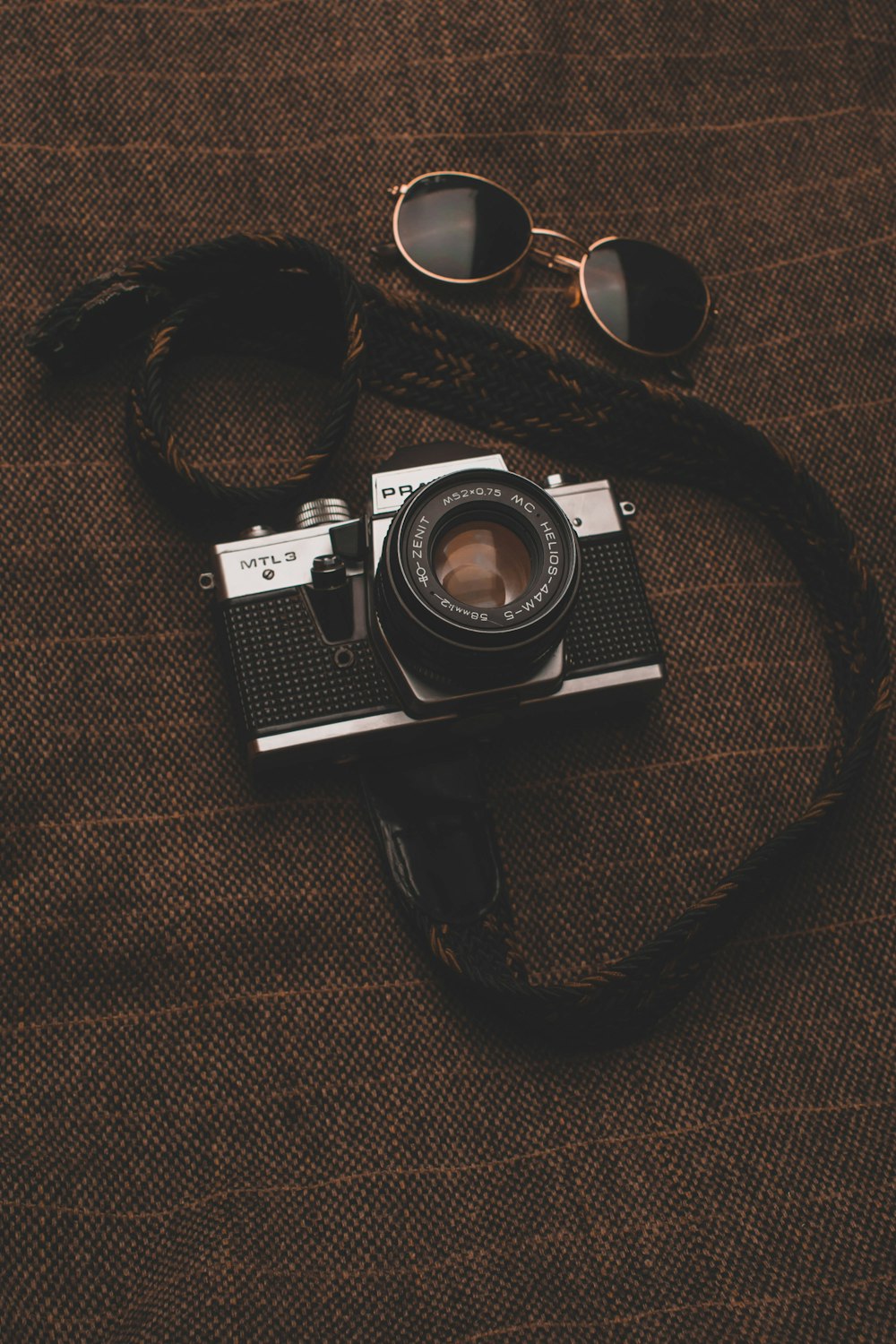 black and silver dslr camera on brown textile