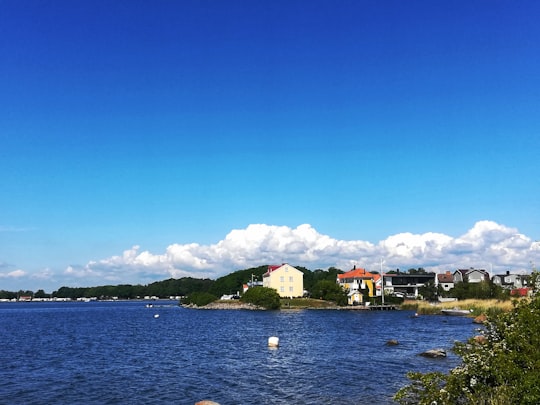 white and red concrete building near body of water during daytime in Karlskrona Sweden