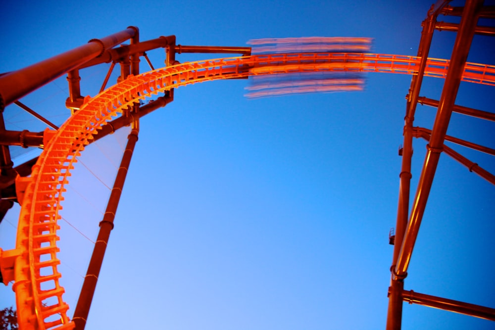 orange and white roller coaster under blue sky during daytime
