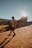 man in white shirt and black shorts standing on brown sand during daytime