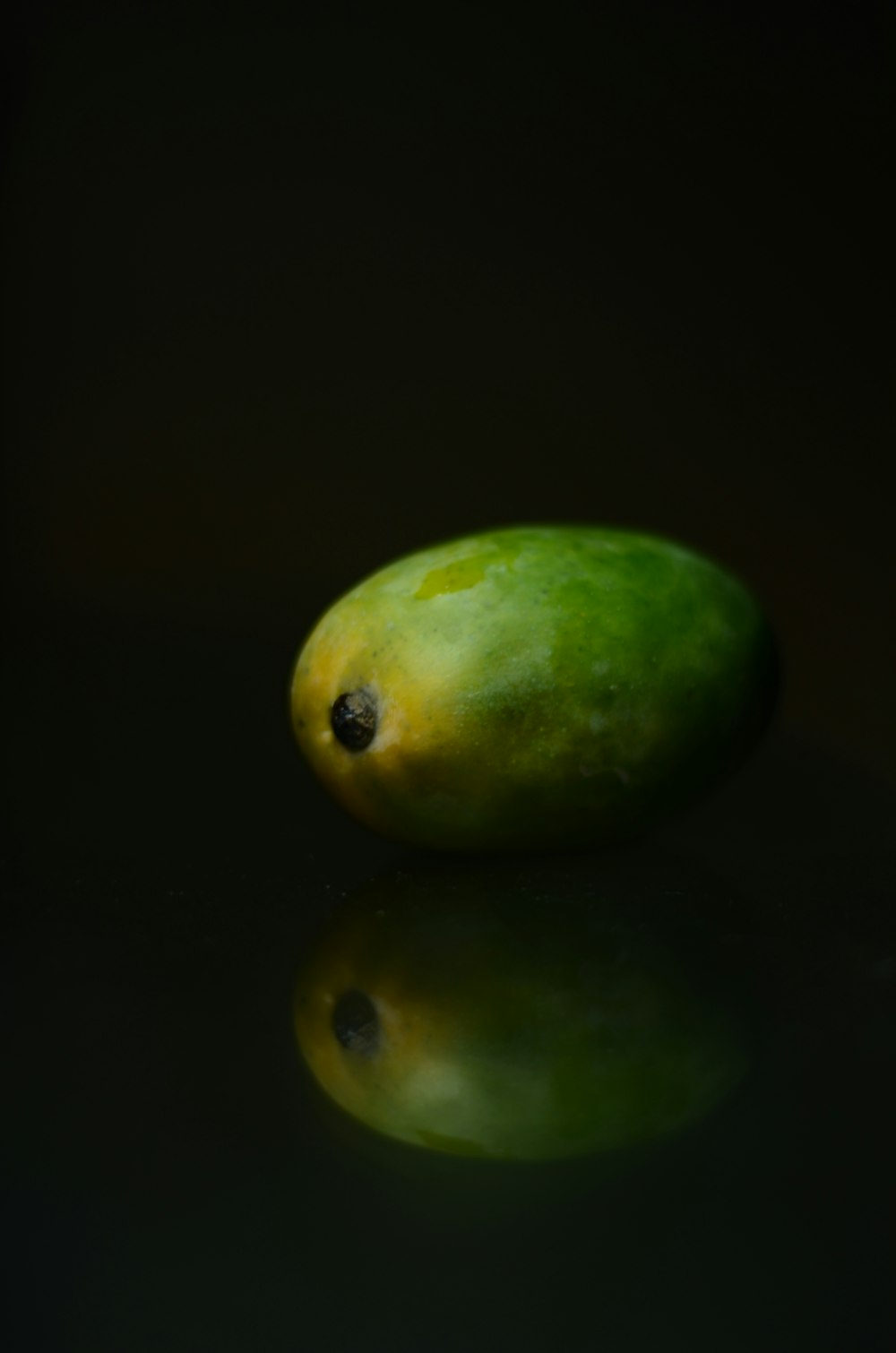 two green round fruits on white surface
