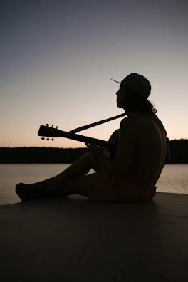 Handpan player immersed in a serene outdoor session at sunset.