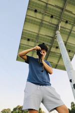 Eng. Mohammad Tamim standing confidently beside a solar panel installation with security cameras in the background.