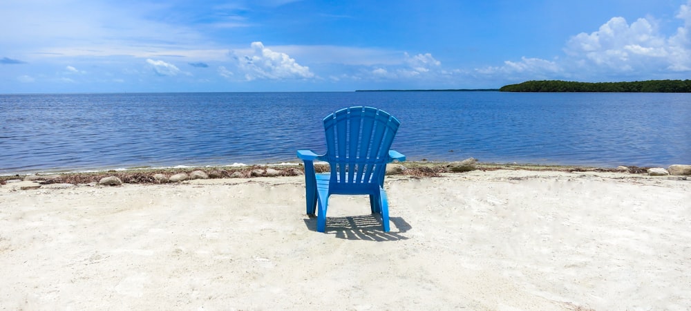 낮 동안 해변에 파란 나무 안락 의자