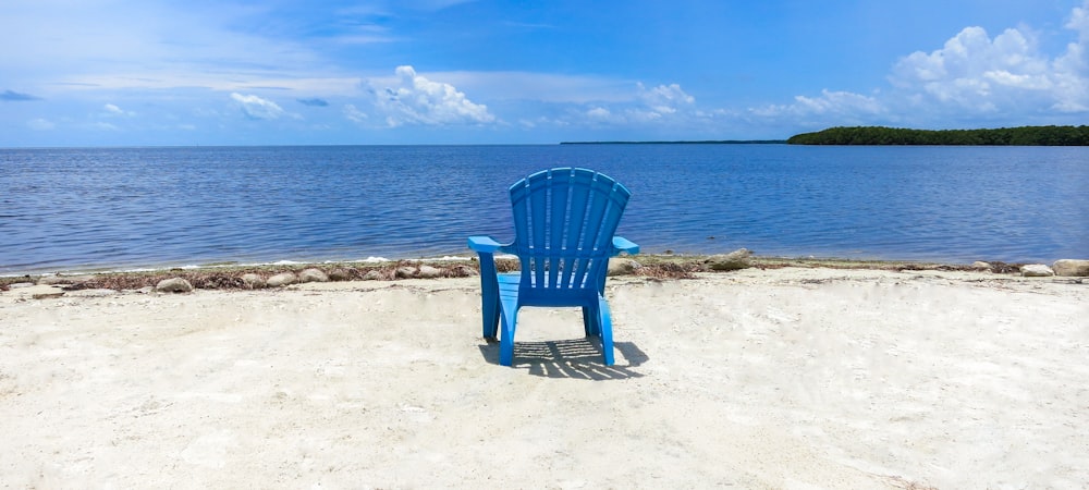 blauer Holzsessel am Strand tagsüber