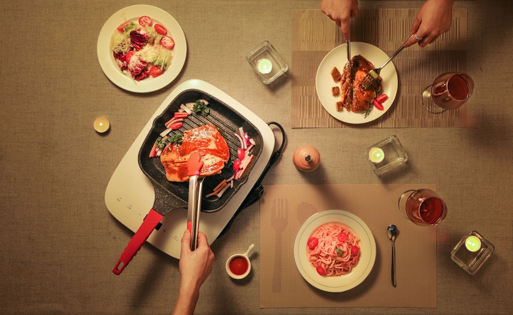 person slicing raw meat on white ceramic plate