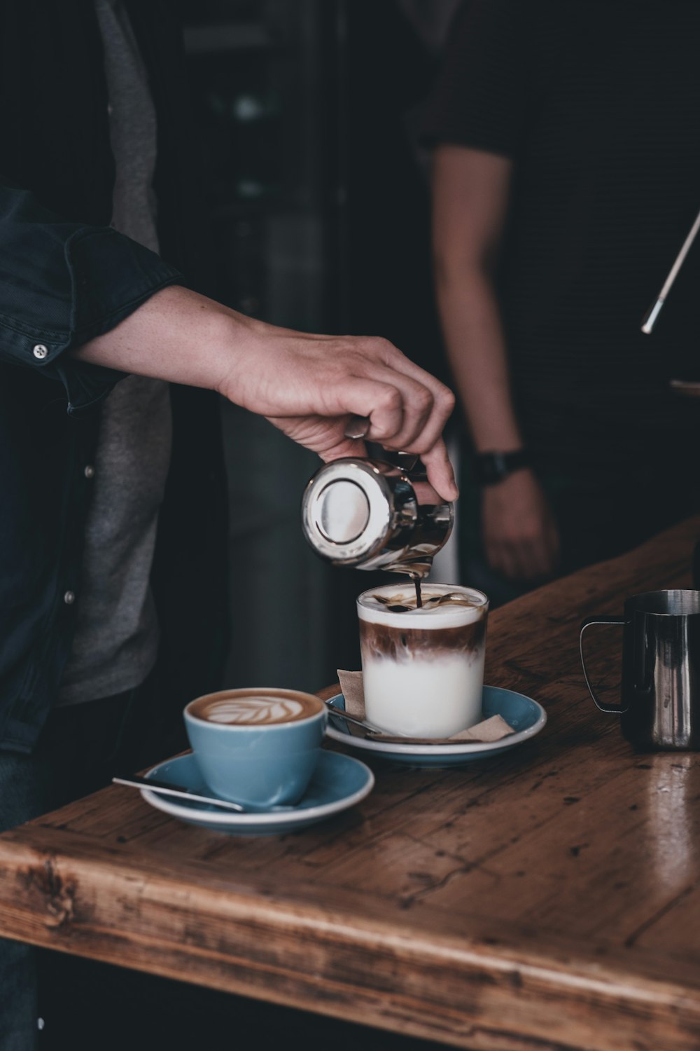 person pouring milk on white ceramic mug