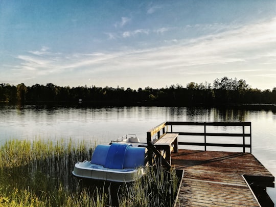 blue and white boat on dock during daytime in Barnsjön Sweden