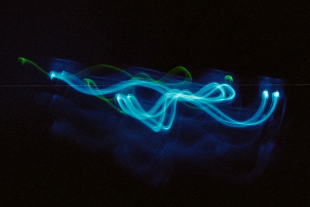 Dynamic electric blue light trails weaving through a dark tech landscape.