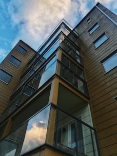 Completed modern apartment building with glass balconies reflecting the sky.