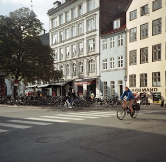 people riding bicycles on road near building during daytime