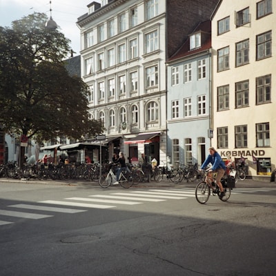 people riding bicycles on road near building during daytime