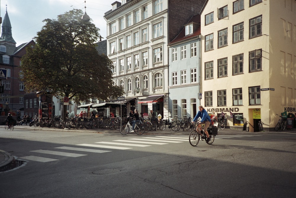 people riding bicycles on road near building during daytime