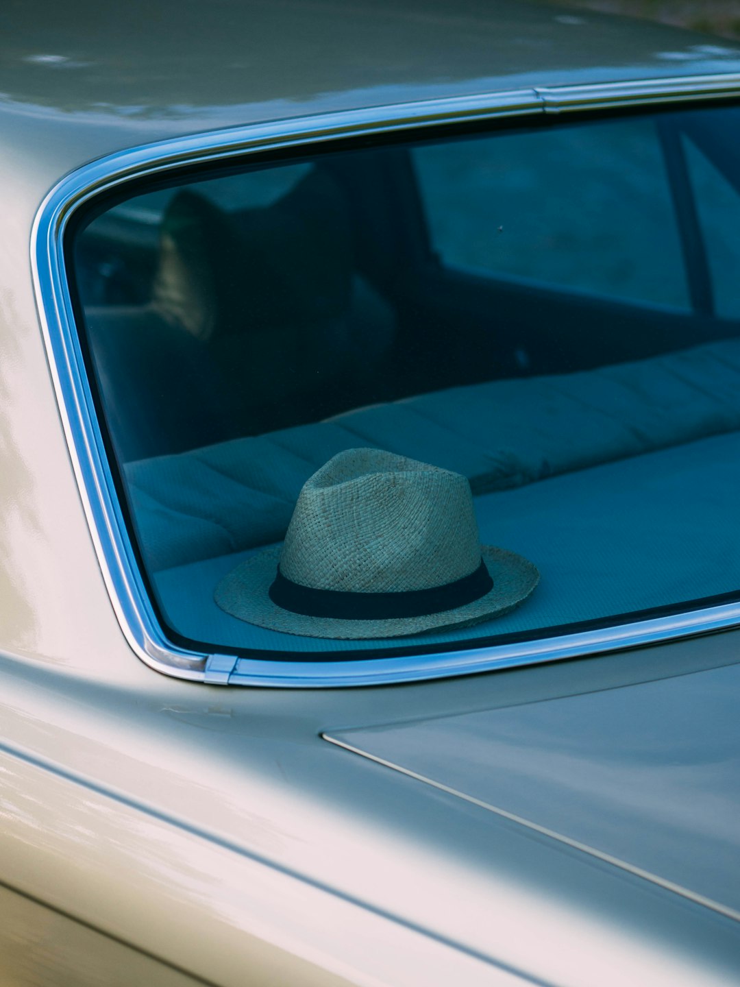 blue fedora hat on car dashboard