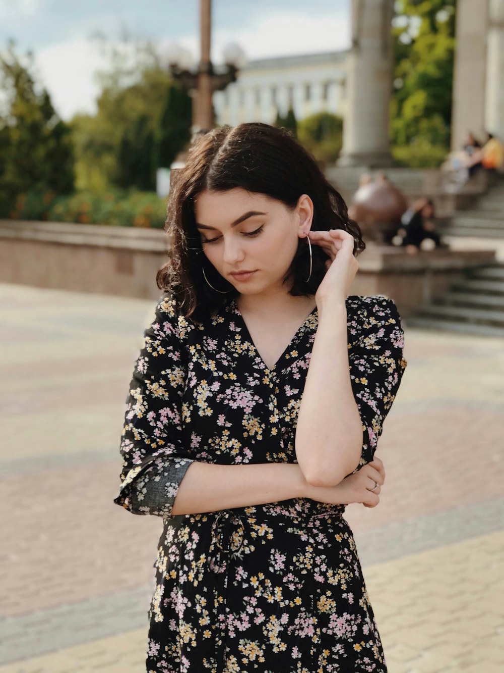 woman in black and white floral dress holding smartphone