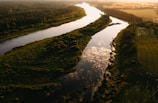 Aerial shot of a winding river at sunset with vibrant colors.