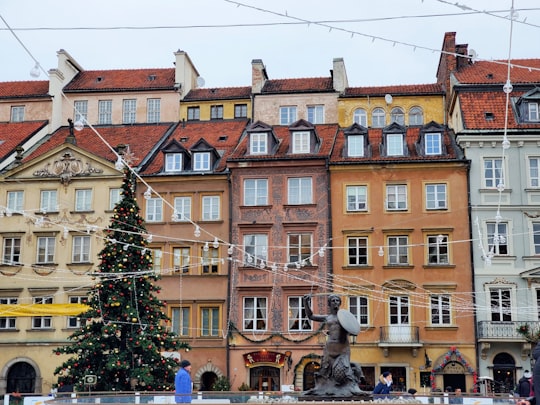 people walking near brown concrete building during daytime in Old Town Market Square Poland