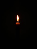 A candle lit in a dark room representing light in darkness.