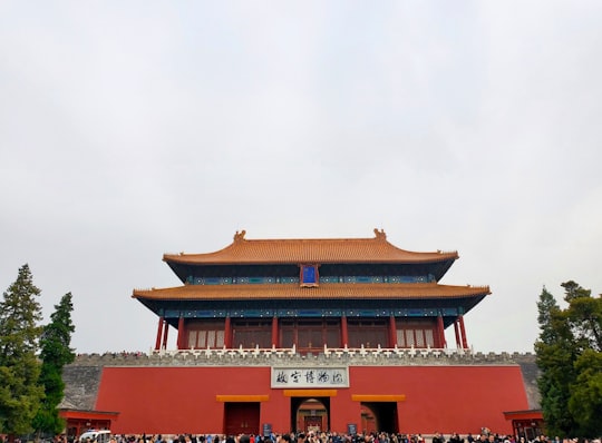 red and white concrete building under white sky during daytime in The Palace Museum China