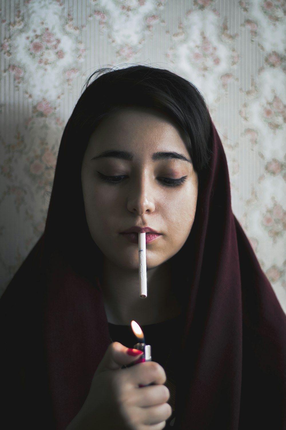 mujer en hiyab marrón fumando cigarrillo