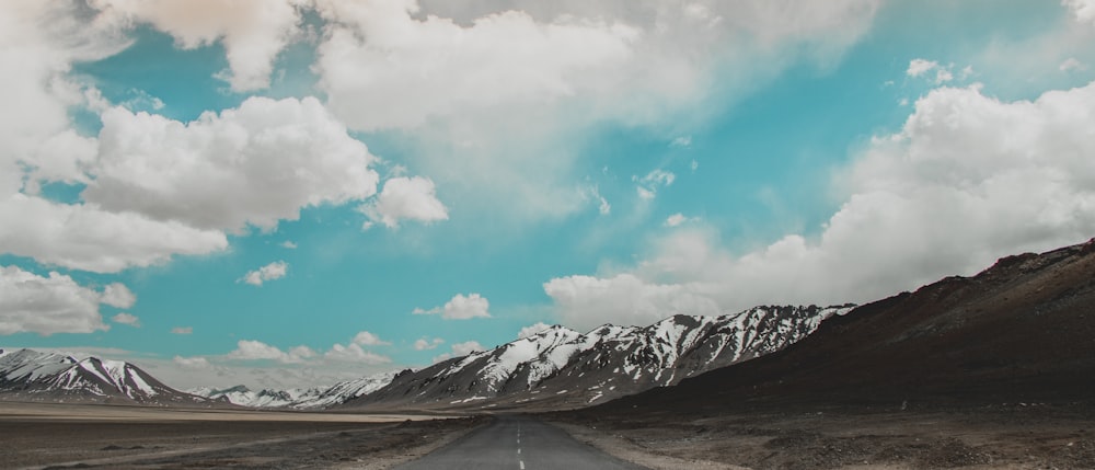 white clouds over snow covered mountain