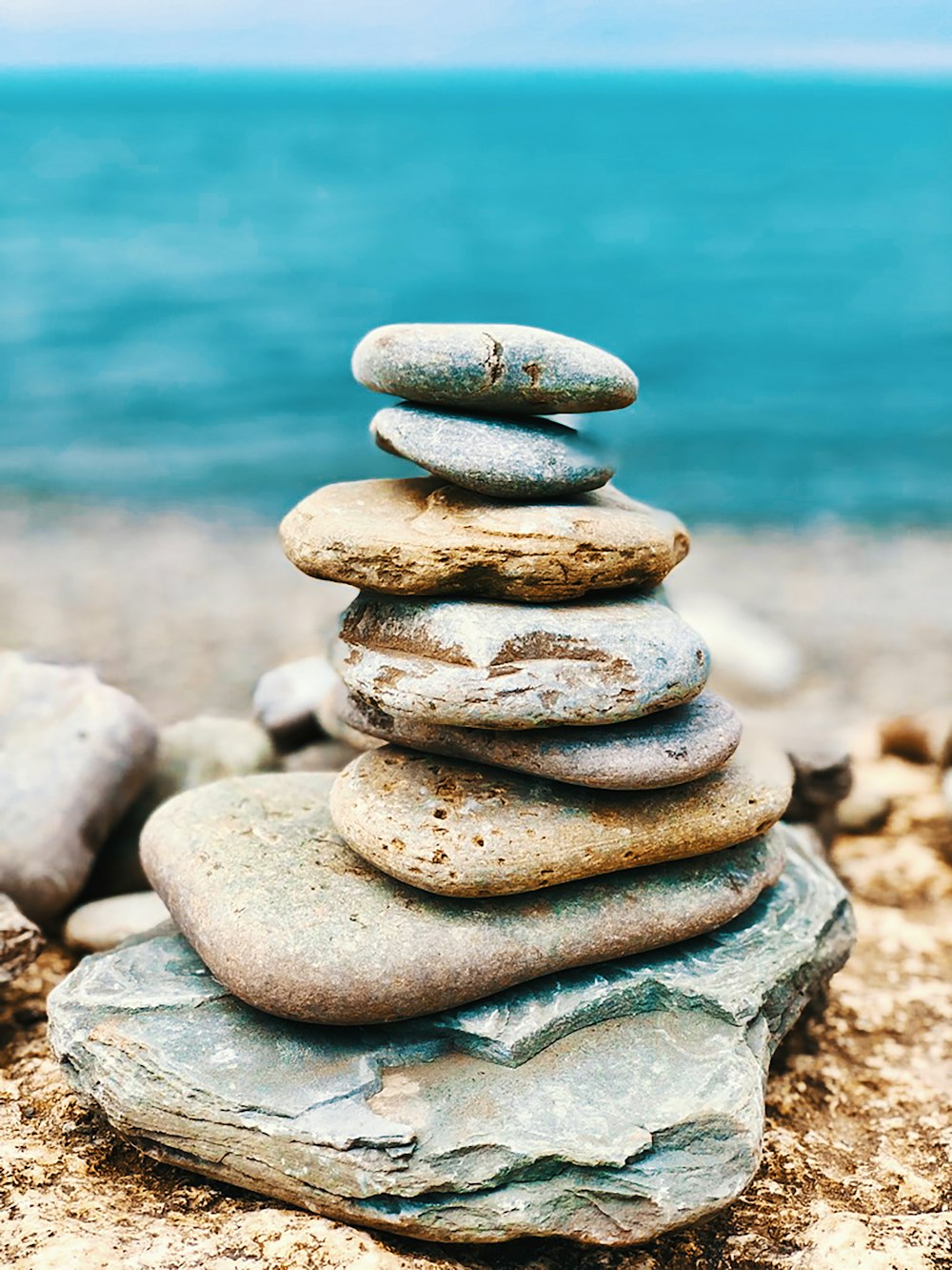 stack of stones near body of water during daytime