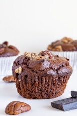 a close up of a chocolate cupcake with nuts