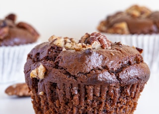 a close up of a chocolate cupcake with nuts