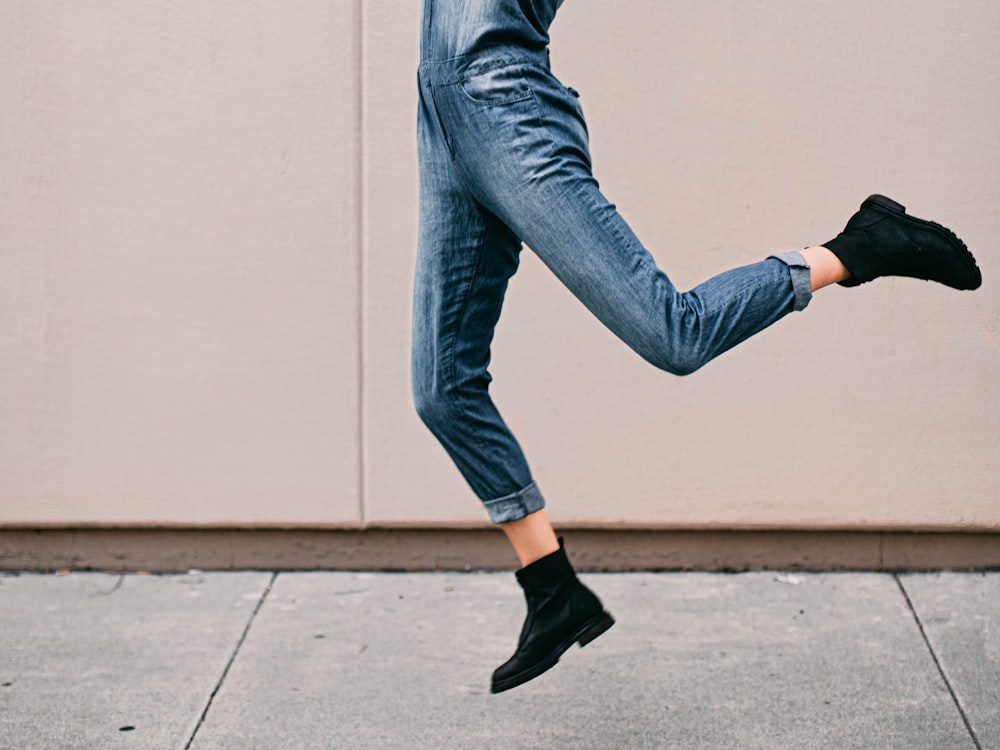 person in blue denim jeans and black leather shoes