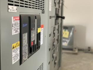 Close-up of electrical panel with NR-10 and NR-12 compliance labels.