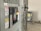A close-up view of an industrial electrical panel with various switches and warning labels. The panel features caution and danger signs in multiple languages, and its metallic surface is complemented by the soft lighting of the room.