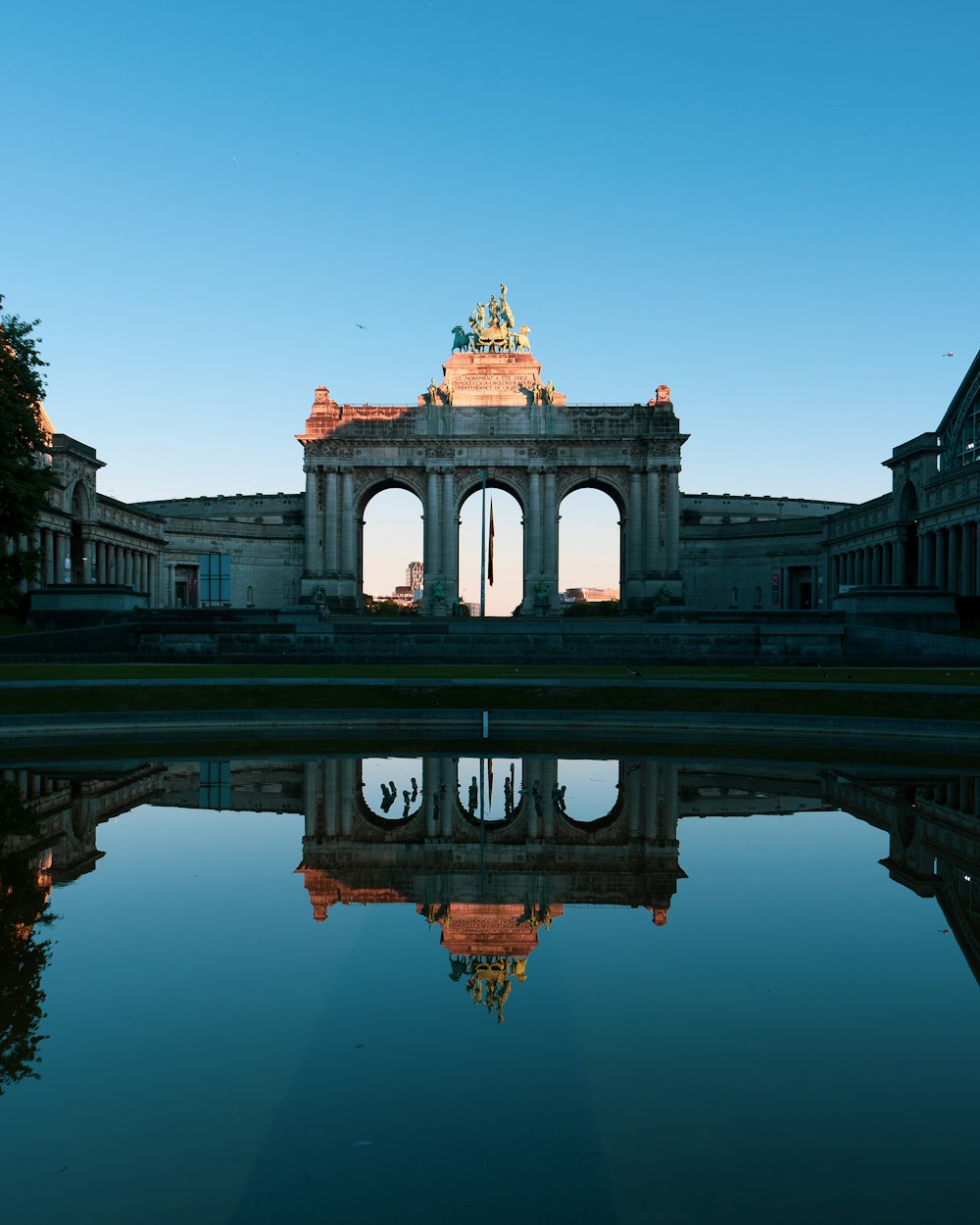 edificio in cemento grigio vicino allo specchio d'acqua durante il giorno