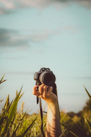 person holding black dslr camera