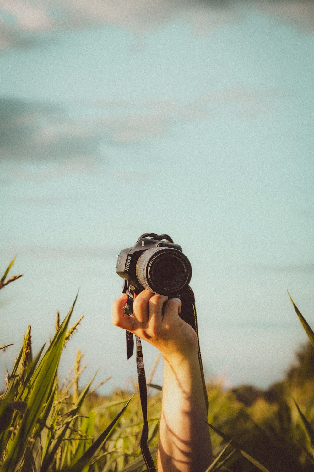 Person mit schwarzer DSLR-Kamera