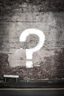 Image of a painted question mark on a brick wall