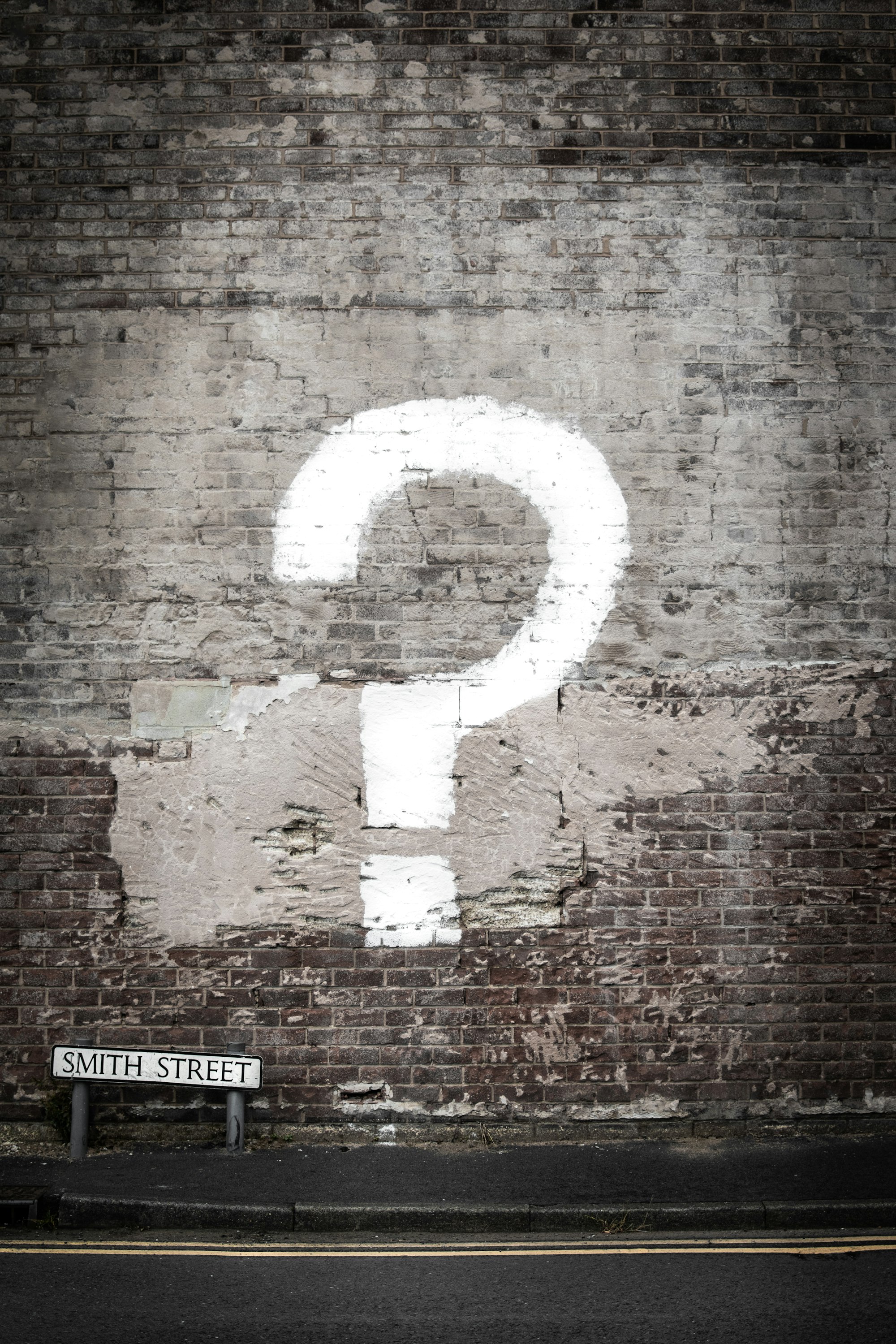 Question mark painted on a brick wall - wornbee.com