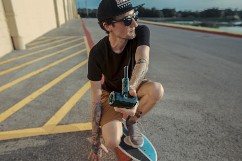 man in black crew neck t-shirt and blue denim shorts sitting on blue and white