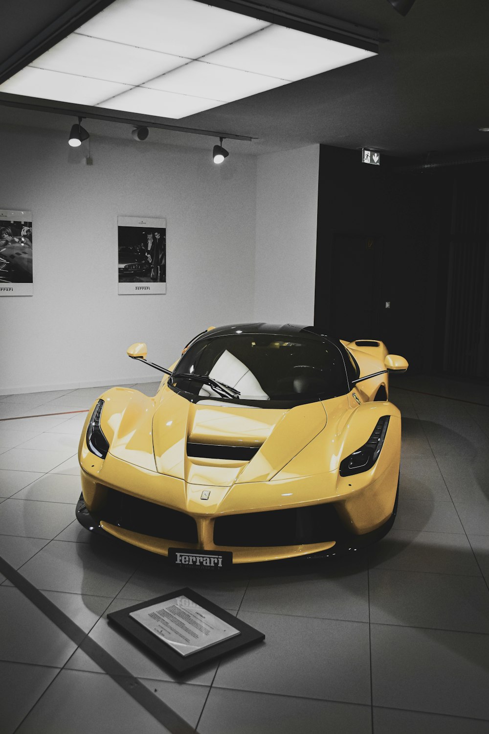 yellow ferrari 458 italia parked on white tiled floor