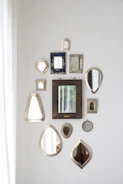 Minimalist arrangement of decorative mirrors with soft cream and dusty rose backgrounds.