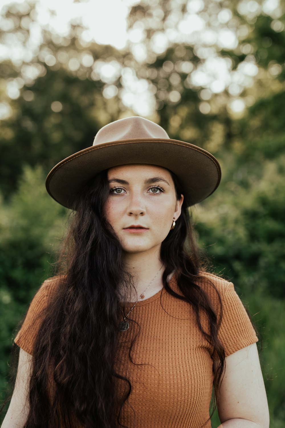 woman in brown hat and orange knit sweater