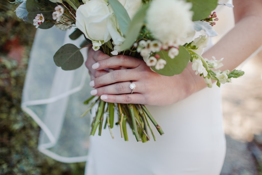 person holding white and green flower bouquet